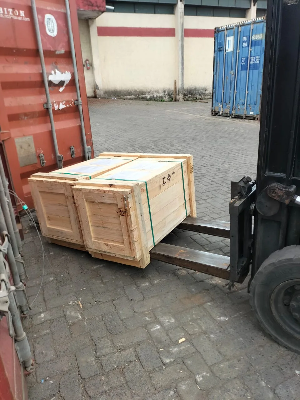 A wooden transport crate beside a shipping container
